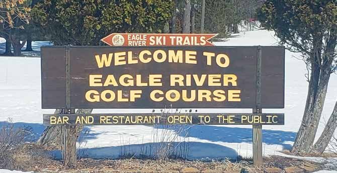 Sign reading “Welcome to Eagle River Golf Course” with snow on the ground.